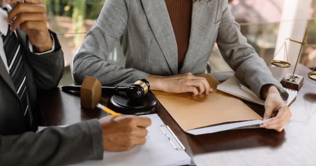 שני אנשים דנים בדיני עבודה ליד שולחן.