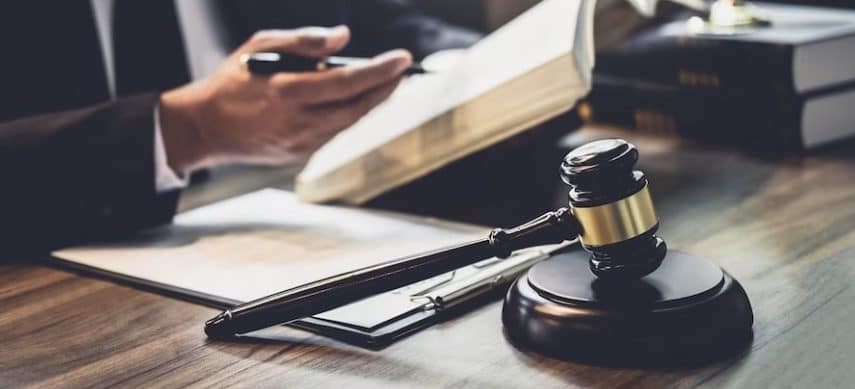 שופט מציג פטיש במהלך הליך משפטי.